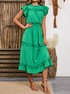 Woman wearing a green Frill Round Neck Cap Sleeve Midi Dress with cinched waist and layered frills, styled with strappy sandals, perfect for casual outings or parties.

