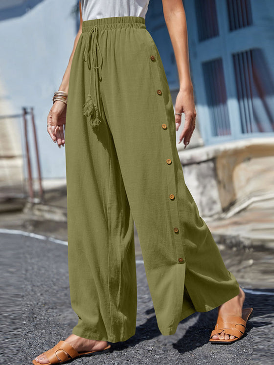 Full Size Tassel Wide Leg Pants with a tasseled tie waist and decorative buttons, designed in a relaxed wide-leg silhouette in green.

