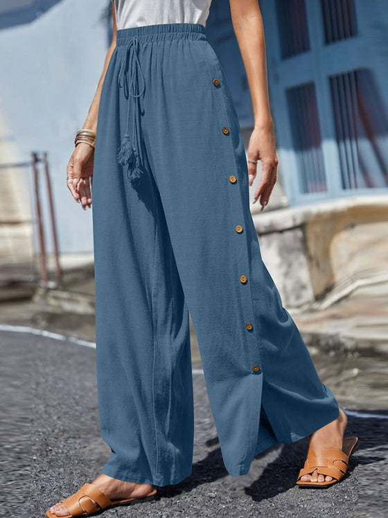 Full Size Tassel Wide Leg Pants with a tasseled tie waist and decorative buttons, designed in a relaxed wide-leg silhouette in green.

