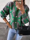 A vibrant geometric-patterned cardigan with dropped shoulders and button closure, styled with casual jeans and a black handbag for a chic winter look.

