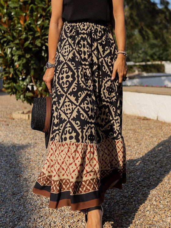 A stylish geometric print elastic waist maxi skirt in earthy tones, paired with a tied white top, ideal for casual and boho-inspired outfits.