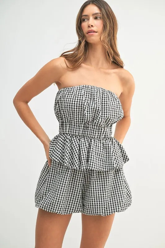 A front-angled photo emphasizing the flared peplum hem and the flattering fit of the high-rise shorts in classic gingham print.

