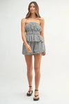 A mid-length image focusing on the structured top with subtle short sleeves and the smooth waistband of the shorts.

