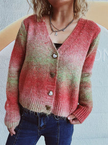  Woman wearing a vibrant gradient V-neck cardigan with heart-shaped buttons, styled with high-waisted jeans for a cozy, chic look.

