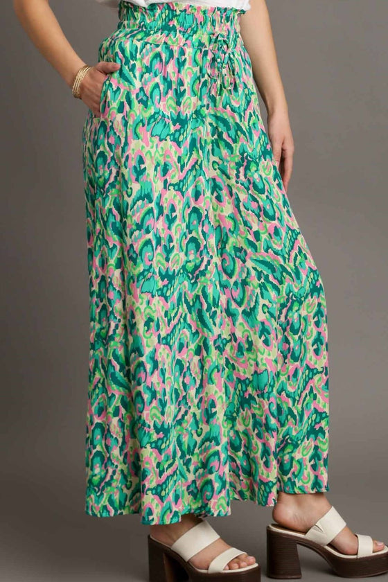 Image captures the soft drape and wide flare of the pants with intricate print placement perfect for warm weather outfits.

