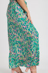 Side angle of the green wide-leg pants revealing their airy structure, elongating silhouette, and subtle flare.

