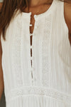 Close-up of the button detail on the sleeveless mini dress, highlighting the lace accents.