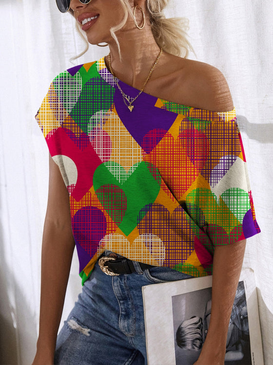 Woman wearing a colorful Heart Single Shoulder Short Sleeve T-Shirt with a bold heart print, styled with high-waisted jeans, perfect for casual outings.