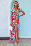  Front-facing view of a hot pink floral printed maxi dress with a waist tie and short sleeves, offering a vibrant and feminine silhouette.