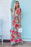 Side profile of the hot pink floral maxi dress showing the flowing structure, tied waist, and soft drape that enhances movement and elegance.

