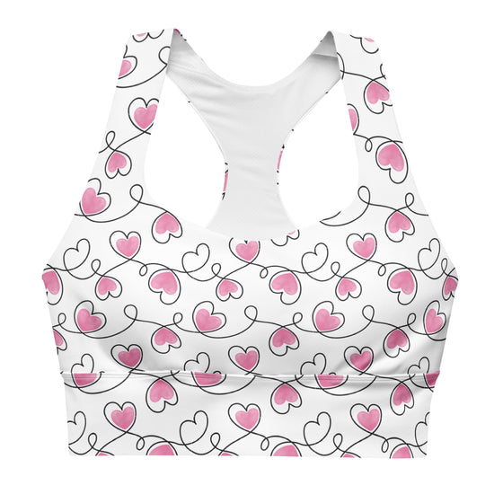 Closeup of heart print on Infinite Hearts white sports bra. Features double-layered front, removable padding, and sleek compression longline design.