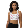 Model wearing Infinite Hearts white high impact sports bra with all-over heart print. Racerback and longline fit provide secure, stylish workout support.