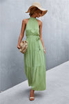 Sleeveless maxi dress with green leaf print and belted waist—lightweight, breathable fabric ideal for sunny days and nature-inspired aesthetics.