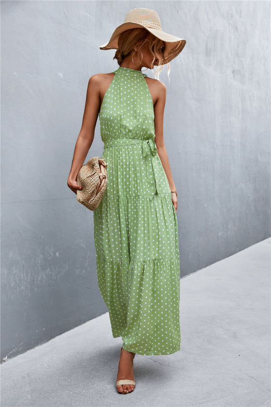 Sleeveless maxi dress with green leaf print and belted waist—lightweight, breathable fabric ideal for sunny days and nature-inspired aesthetics.