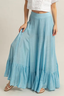   Front view of light blue wide leg pants featuring ruffle details and a high waist.