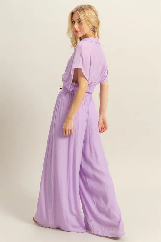 A back-facing image capturing the seamless back design of the top and the clean, tailored drape of the matching wide-leg pants.


