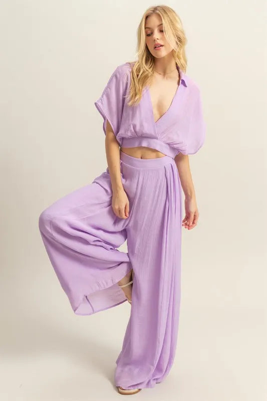 A full front view of the soft light purple two-piece set featuring a short-sleeve top paired with flowy, high-waisted wide-leg pants for a chic and coordinated look.

