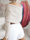 Back view of a long sleeve cropped knit top in neutral beige, styled with high-waisted white shorts.