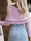 Back view of a long sleeve cropped knit top in neutral beige, styled with high-waisted white shorts.