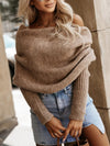 Lifestyle shot of a woman wearing a long sleeve cropped knit top with a stylish belt and accessories.