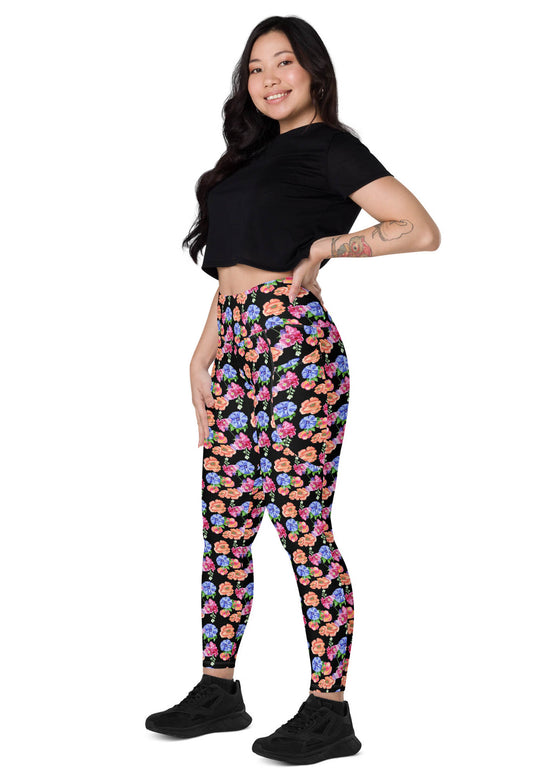 Model sitting sideways in Black Floral High Waisted Leggings with Pockets, showcasing the stylish floral print and the comfort and flexibility ideal for yoga and casual wear.