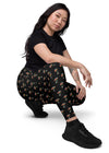 Model sitting back in Zen Frog black high-waisted leggings with pockets, showing the sleek fit and frog print, designed for relaxation and activity.