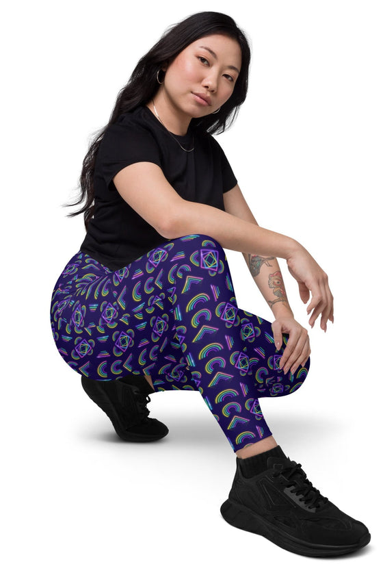 Model seated in Neon Rainbow Navy High Rise Leggings, front view, emphasizing the functional design and secure waistband for all-day wear.