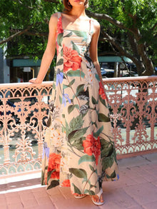 Model wearing the peach multicolor printed maxi dress, facing forward with a smile, showcasing the square neckline, flowing hem, and vibrant summer print.

