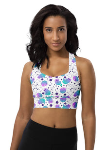  Woman wearing the Neon Cosmic White Racerback Sports Bra with a vibrant neon cosmic print. Offers high sports bra support and moisture-wicking fabric for gym workouts and active fitness routines.