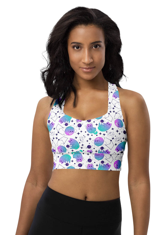 Woman wearing the Neon Cosmic White Racerback Sports Bra with a vibrant neon cosmic print. Offers high sports bra support and moisture-wicking fabric for gym workouts and active fitness routines.