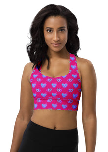  Woman wearing the Neon Heart Violet Red Racerback Sports Bra. Featuring a bold neon heart pattern in red and violet, designed for high-impact support with a racerback fit and breathable fabric for intense workouts.