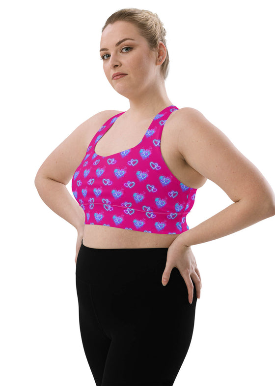 Side view of the Neon Heart Violet Red Racerback Sports Bra in large size. Showcasing the vibrant neon heart print with a supportive fit, moisture-wicking fabric, and a stylish racerback design for gym workouts.
