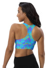 Back view of woman wearing Neon Hearts Print Blue High Impact Sports Bra. Racerback design offers full range of motion, while double-layered fabric ensures high support and stability for intense activities.