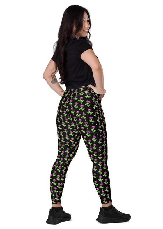 Model showcasing the convenient side pockets of neon roses black high-waisted leggings. Designed with a stylish floral print and high-waisted fit for a flattering and functional look.
