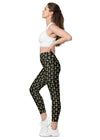 Side view of a woman wearing neon roses black high-waisted leggings with pockets. Designed with a sleek black base and neon floral prints, perfect for gym workouts or yoga.
