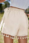 Back close-up of tie waist wrap skirt in neutral beige, highlighting tassel-trimmed hem and elegant drape—perfect for laid-back yet refined fashion.