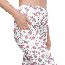  Closeup of white high waisted leggings with never ending hearts print and side pocket. Compression leggings with pockets for women, ideal for daily wear.