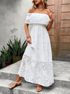 Lifestyle image of a woman wearing the off-shoulder maxi dress, paired with a sunhat and sandals, perfect for summer outings.