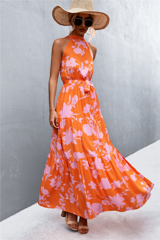 Orange maxi dress with a tropical-inspired print and tie waist—sleek and breezy, ideal for vacations, poolside lounging, or brunch dates.
