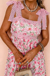 Close front view of the square neckline and bodice of the pink floral dress, featuring delicate floral patterns and a softly structured fit.


