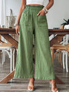 Green wide-leg pants with an elastic waistband and functional pockets, offering a relaxed and stylish look for casual outings or daily wear.

