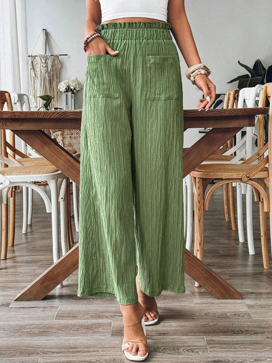 Model styling the Pocketed Elastic Waist Wide Leg Pants in green, paired with a white top for a casual, everyday look.