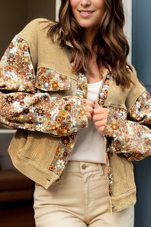  Woman wearing a printed floral long sleeve jacket with a collared neckline and buttoned front, styled with neutral-toned pants for a casual chic look.