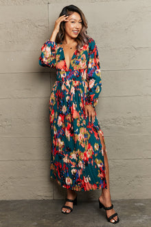  Woman wearing a bold multicolored maxi dress with a deep V-neckline and thigh-high slit, ideal for making a chic statement.