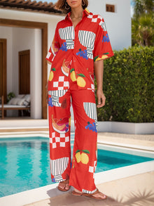  Model wearing a printed two-piece set with a dropped shoulder button-up top and wide-leg pants, perfect for casual summer outings.

