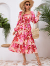 Woman wearing a Printed Long Sleeve Midi Dress featuring a tied waist, off-shoulder neckline, and vibrant print, perfect for casual outings or evening wear.