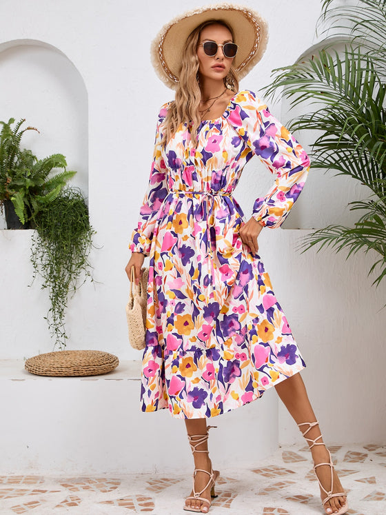 Woman wearing a Printed Long Sleeve Midi Dress featuring a tied waist, off-shoulder neckline, and vibrant print, perfect for casual outings or evening wear.