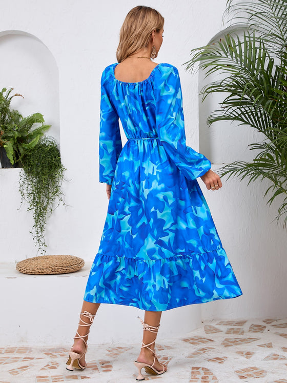 Back view of the Printed Long Sleeve Midi Dress showcasing its vibrant prints, tied waist, and off-shoulder neckline.