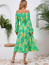 Back view of the Printed Long Sleeve Midi Dress showcasing its vibrant prints, tied waist, and off-shoulder neckline.