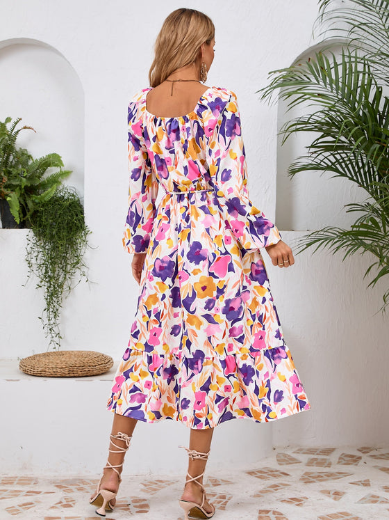 Back view of the Printed Long Sleeve Midi Dress showcasing its vibrant prints, tied waist, and off-shoulder neckline.